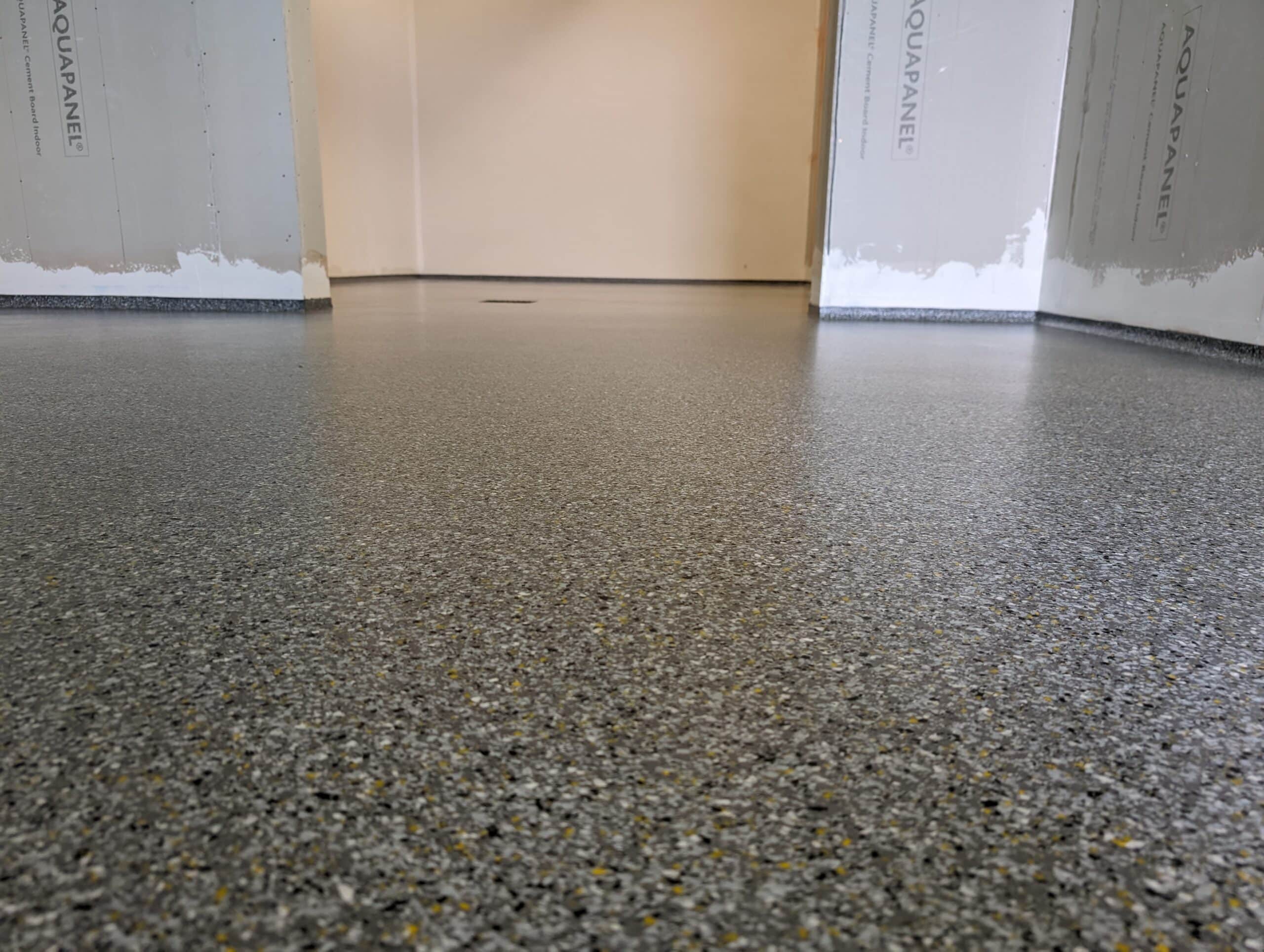 Nahaufnahme eines strapazierfähigen, dekorativen Epoxidharzbodens in einem Raum.