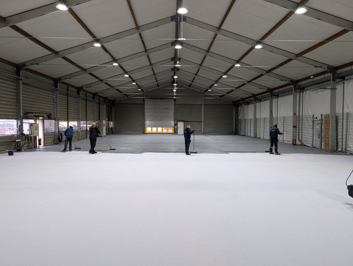 Moderne Hallenbodenbeschichtung in einer großen Lagerhalle, professionell aufgetragen.